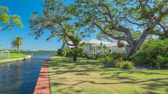 view of home's community with a yard and a water view