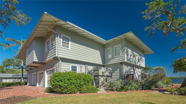 1249 S Basin Ln, Sarasota, FL 34242 - view of side of home with a garage and a yard