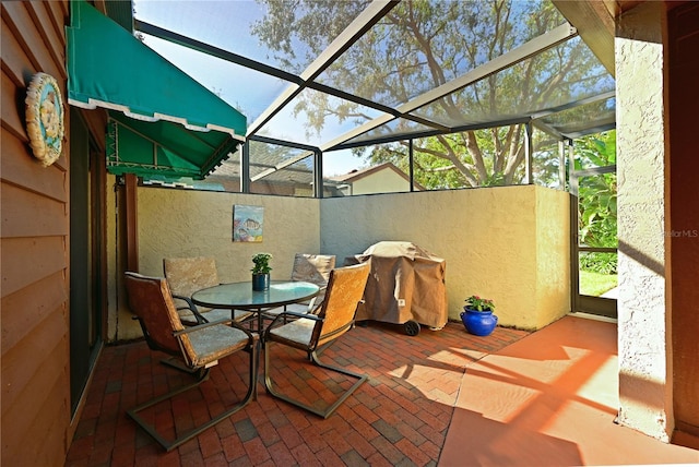 view of patio / terrace with glass enclosure and a grill