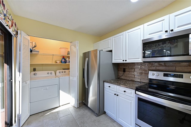 kitchen featuring decorative backsplash, stainless steel appliances, washing machine and clothes dryer, white cabinets, and light tile patterned flooring