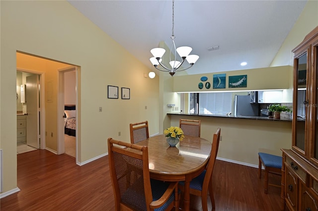 dining area featuring dark wood-type flooring, lofted ceiling, and a notable chandelier