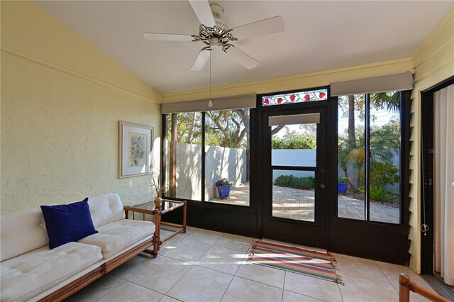 sunroom / solarium featuring ceiling fan, a healthy amount of sunlight, and vaulted ceiling