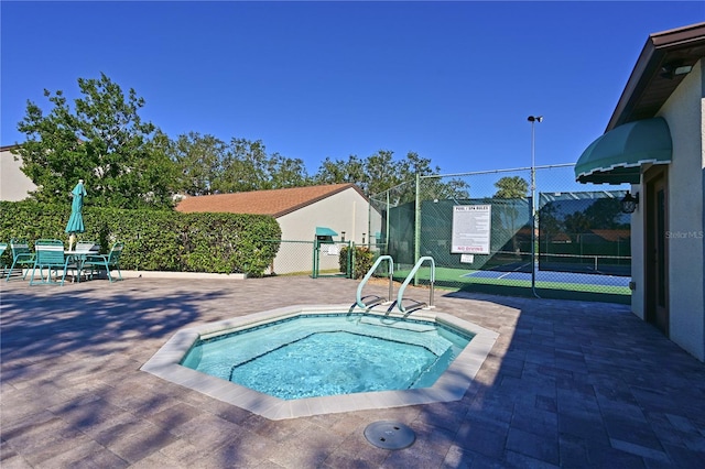 view of swimming pool featuring tennis court