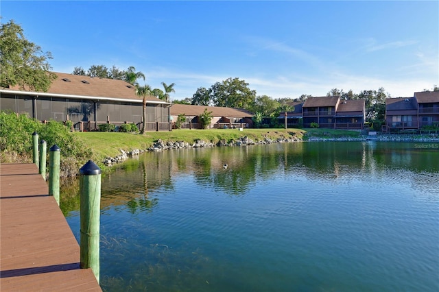 view of dock featuring a lawn and a water view