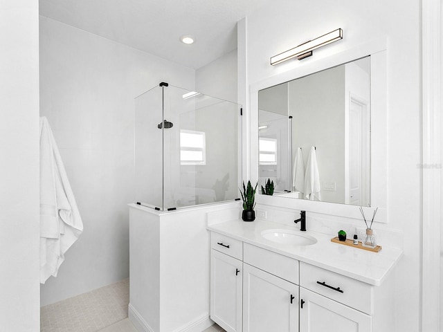 bathroom featuring a tile shower, vanity, and tile patterned floors