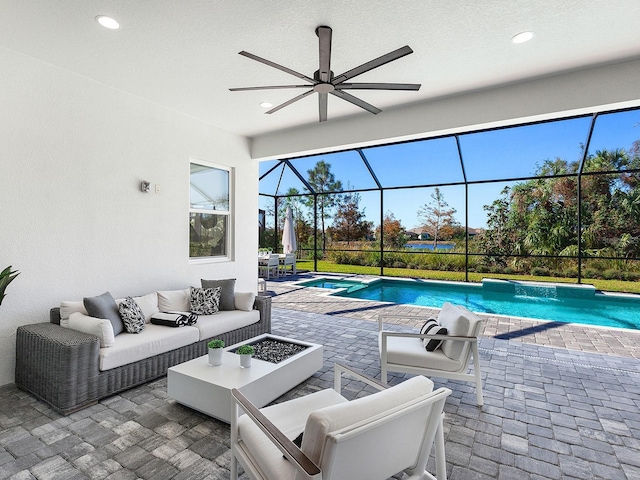 view of pool with outdoor lounge area, glass enclosure, and a patio area