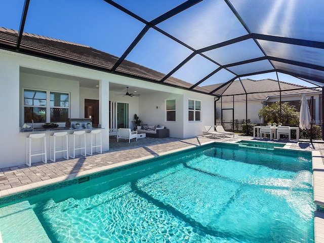 view of pool with a lanai, an outdoor living space, ceiling fan, a patio, and an outdoor bar