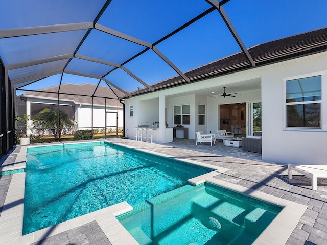 view of pool with glass enclosure, ceiling fan, an outdoor hangout area, a bar, and a patio