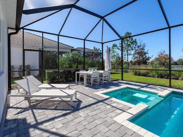 view of swimming pool with glass enclosure, a patio area, and an in ground hot tub