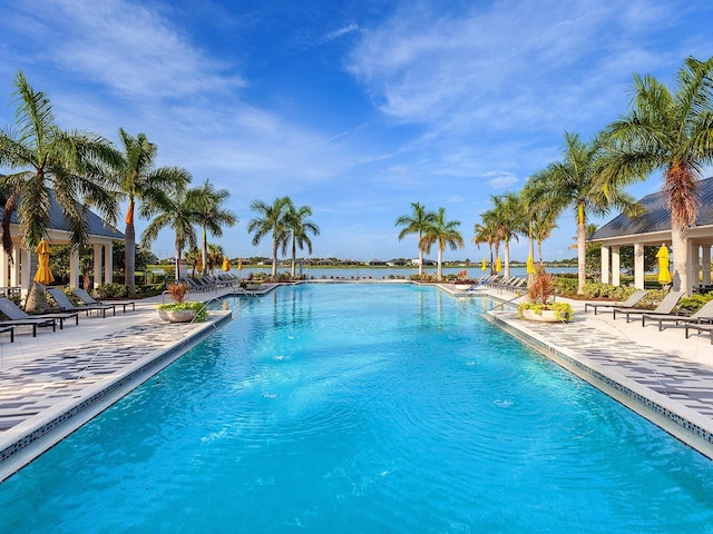 view of pool featuring a patio and a water view