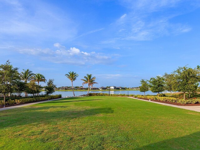 surrounding community featuring a water view and a yard