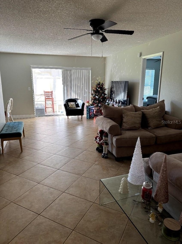 living room featuring a textured ceiling, ceiling fan, and light tile patterned flooring