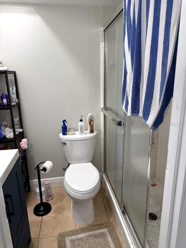 bathroom featuring toilet, vanity, tile patterned floors, and walk in shower