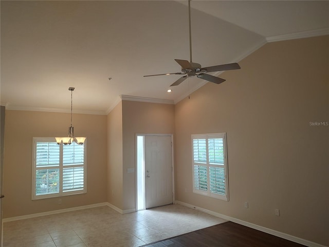 tiled entryway featuring ceiling fan with notable chandelier, lofted ceiling, and crown molding