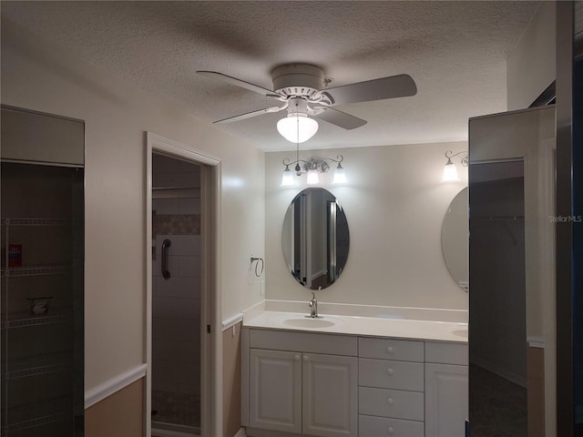 bathroom featuring vanity, ceiling fan, and a textured ceiling