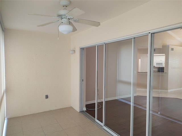 unfurnished sunroom with ceiling fan