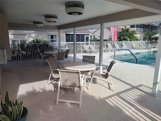 view of patio with ceiling fan and a community pool