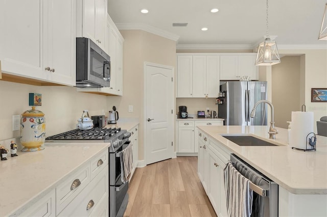 kitchen featuring white cabinets, sink, stainless steel appliances, and hanging light fixtures