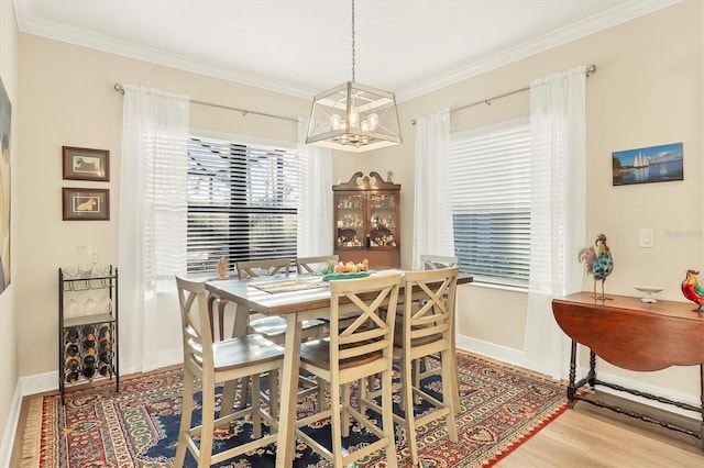 dining area with a chandelier, hardwood / wood-style floors, and ornamental molding