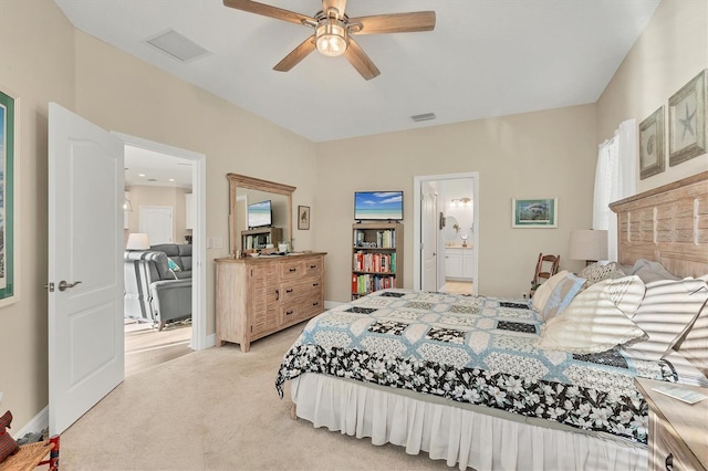 bedroom featuring light carpet, connected bathroom, and ceiling fan