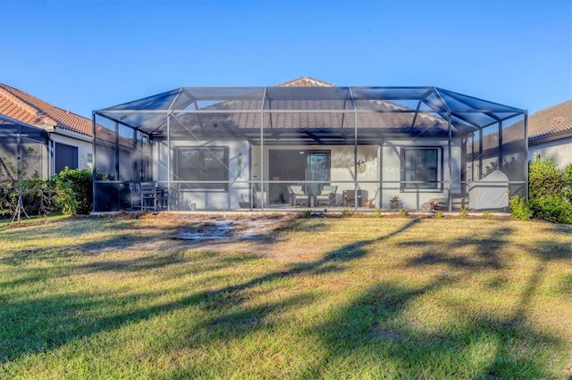 back of property with a lanai and a lawn