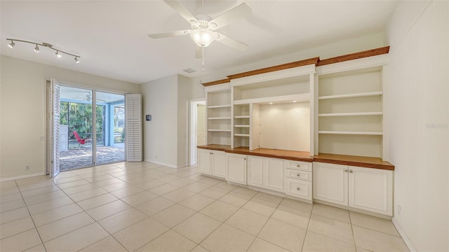 unfurnished living room featuring light tile patterned floors and ceiling fan