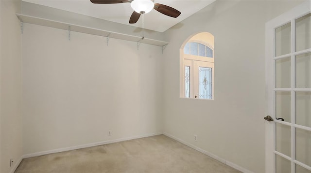 carpeted spare room featuring a wealth of natural light and ceiling fan