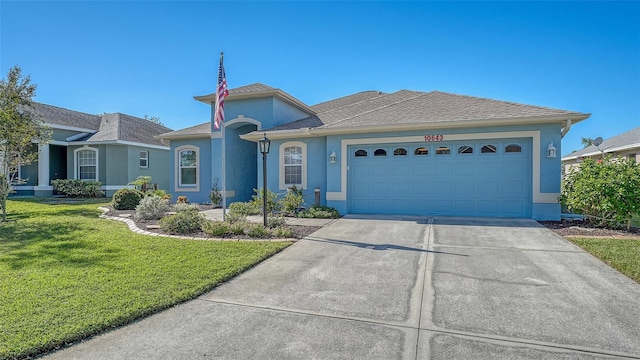 ranch-style home with a garage and a front lawn