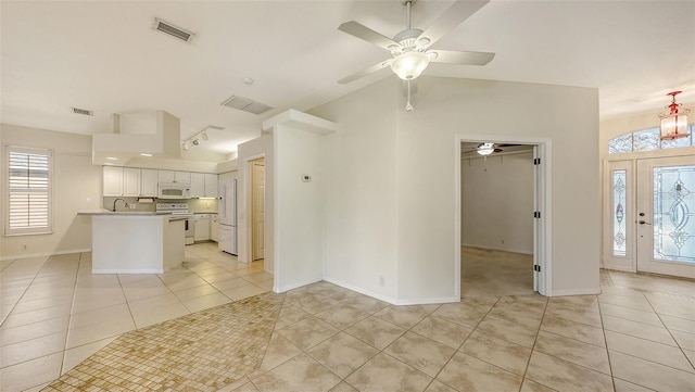 unfurnished living room featuring light tile patterned floors, sink, and ceiling fan