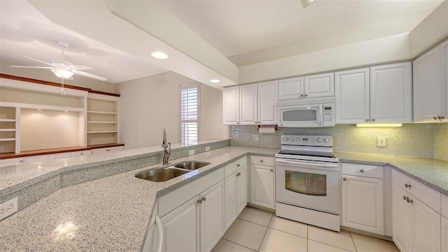 kitchen with sink, white cabinets, white appliances, light stone countertops, and backsplash