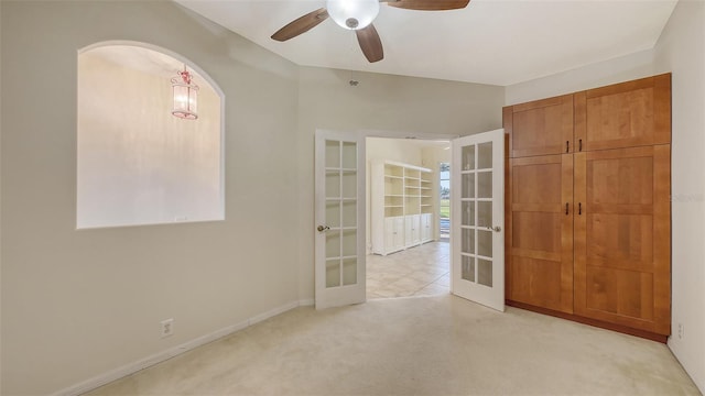 carpeted spare room featuring french doors and ceiling fan