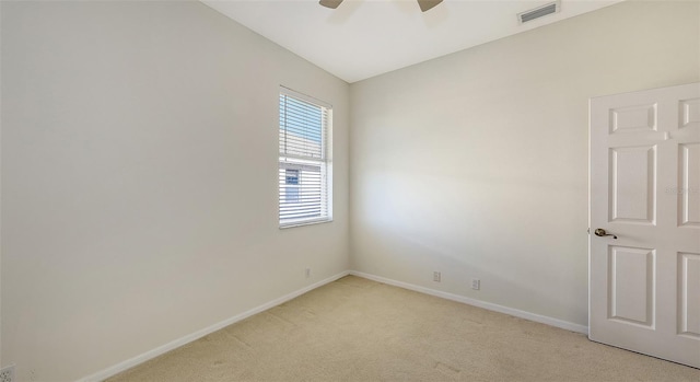 spare room with light colored carpet and ceiling fan