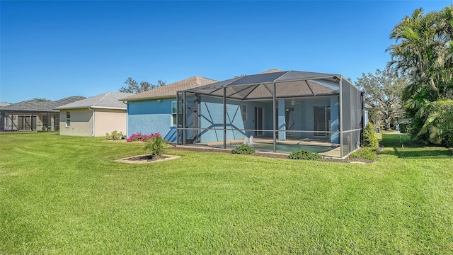 back of house featuring a yard and glass enclosure