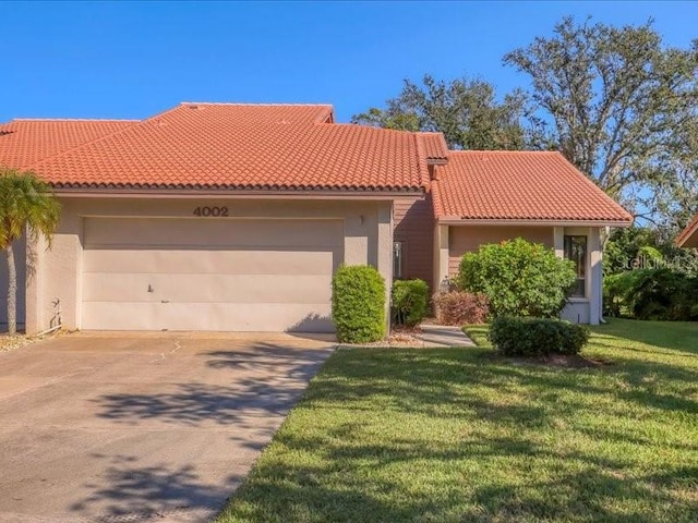 mediterranean / spanish home with a garage and a front lawn