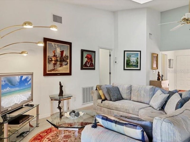 living room featuring ceiling fan and a towering ceiling