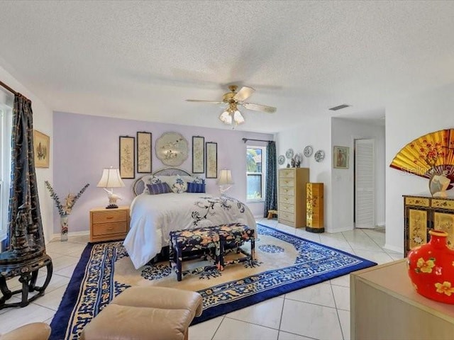 tiled bedroom with a textured ceiling and ceiling fan