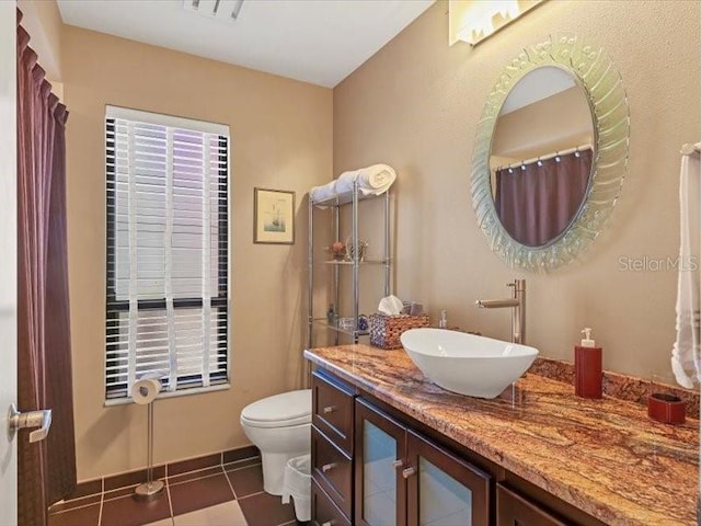 bathroom with tile patterned flooring, vanity, and toilet