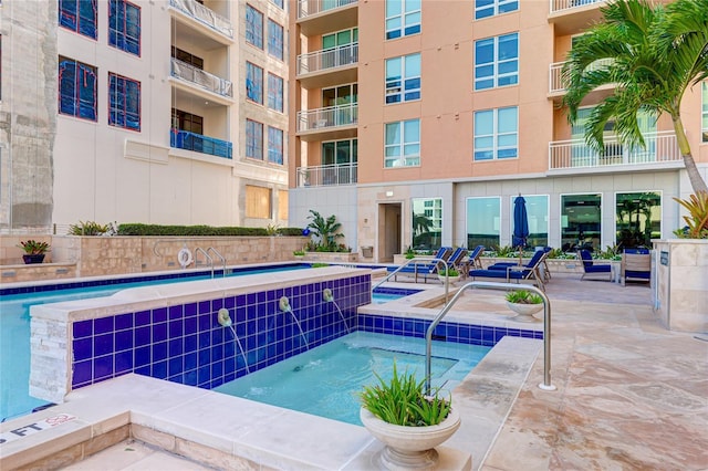 view of pool with a patio area and a hot tub