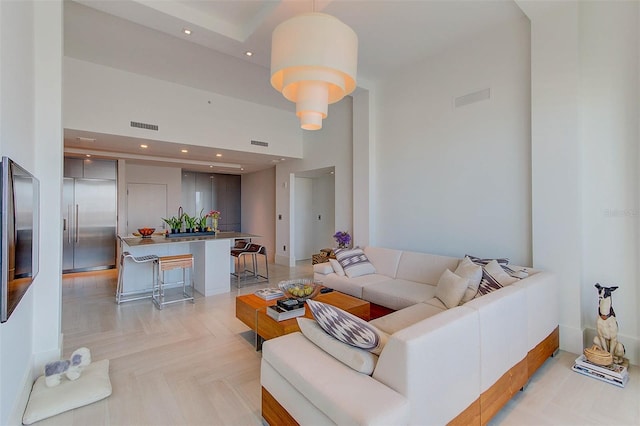 living room featuring light parquet flooring and a high ceiling