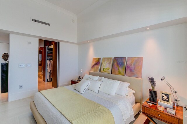 bedroom featuring a spacious closet, a high ceiling, and a closet