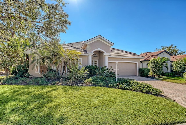 mediterranean / spanish-style house with a front yard and a garage