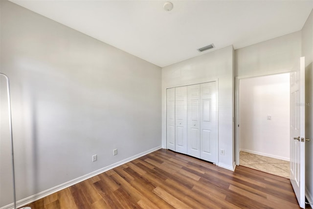 unfurnished bedroom featuring dark hardwood / wood-style flooring and a closet