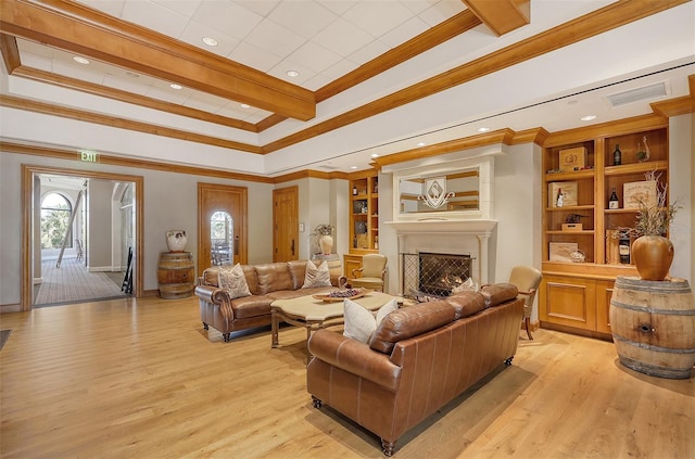 living room with crown molding, built in features, and light hardwood / wood-style floors