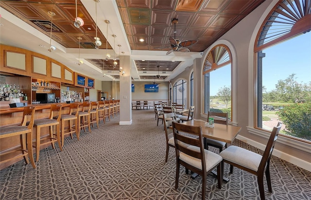 dining space with carpet flooring, indoor bar, plenty of natural light, and ceiling fan