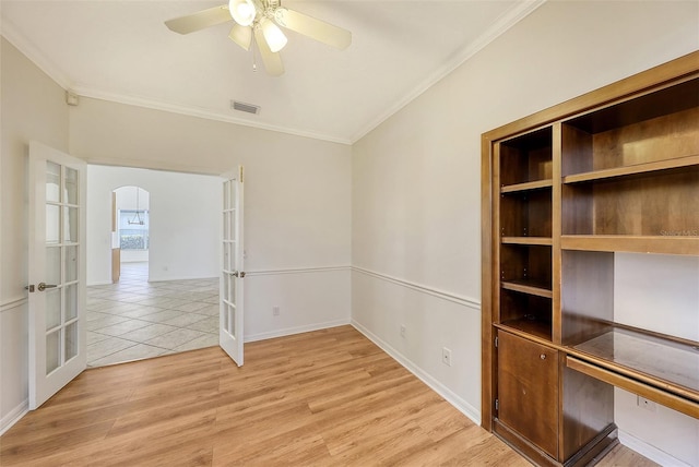 empty room featuring crown molding, ceiling fan, french doors, and light hardwood / wood-style floors