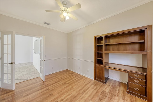 unfurnished office with ceiling fan, french doors, light hardwood / wood-style flooring, built in desk, and ornamental molding