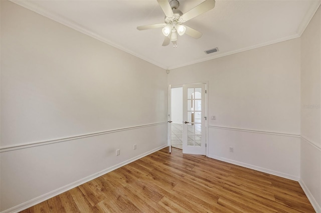 spare room with french doors, light wood-type flooring, ceiling fan, and ornamental molding