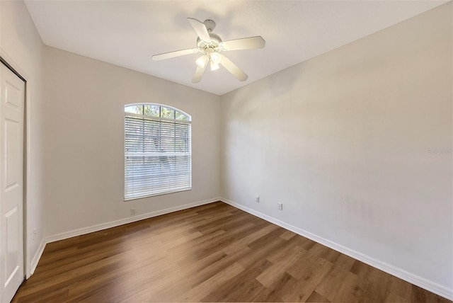 empty room with ceiling fan and dark hardwood / wood-style flooring