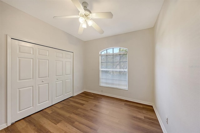 unfurnished bedroom with ceiling fan, a closet, and light hardwood / wood-style floors