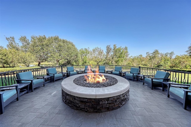 view of patio with an outdoor living space with a fire pit